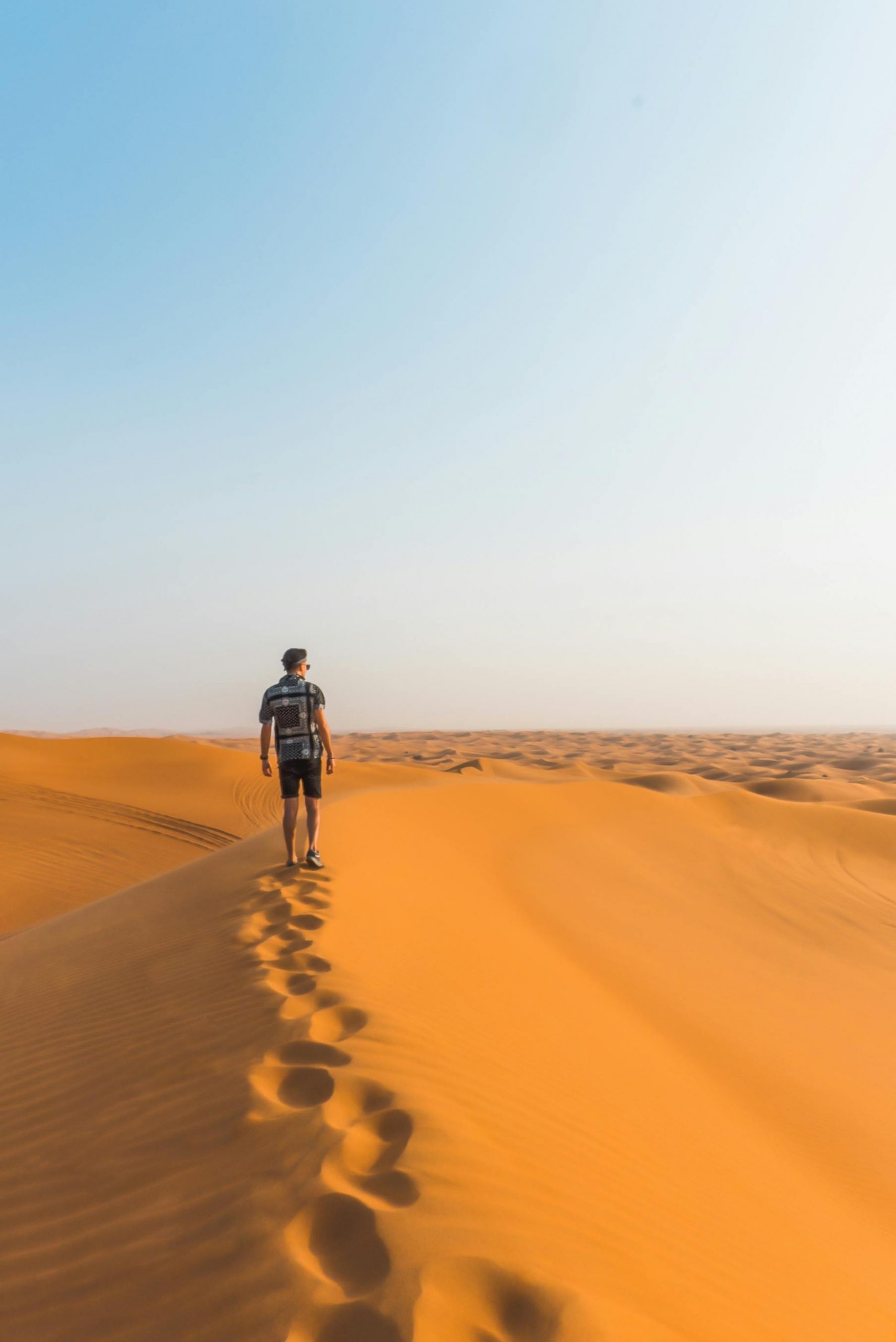 Voyageur contemplant l'immensité des dunes à Lompoul Nature, entre sable et horizon marin.