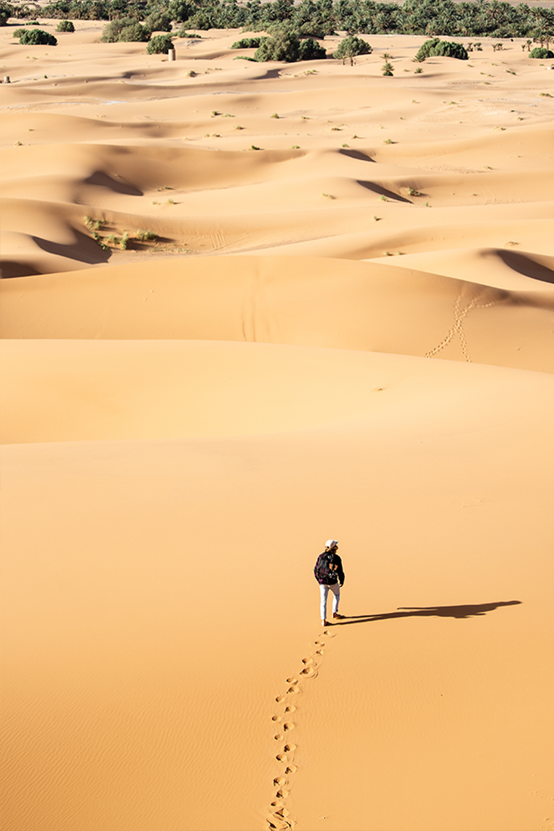 Voyageur en pleine immersion lors d'une marche dans les dunes de Lompoul Nature.